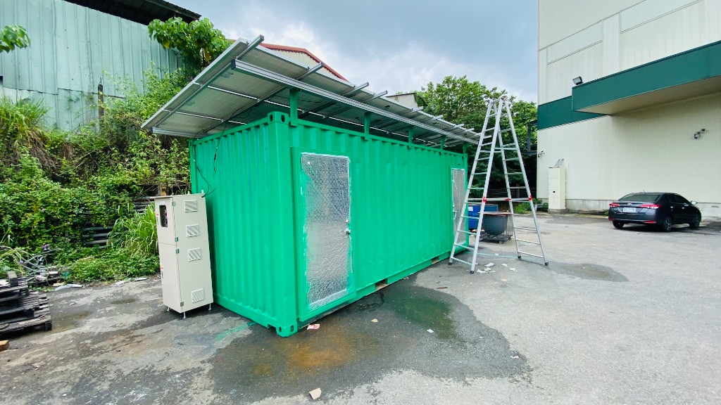 綠色貨櫃模組與屋頂太陽能板、一旁為戶外配電櫃